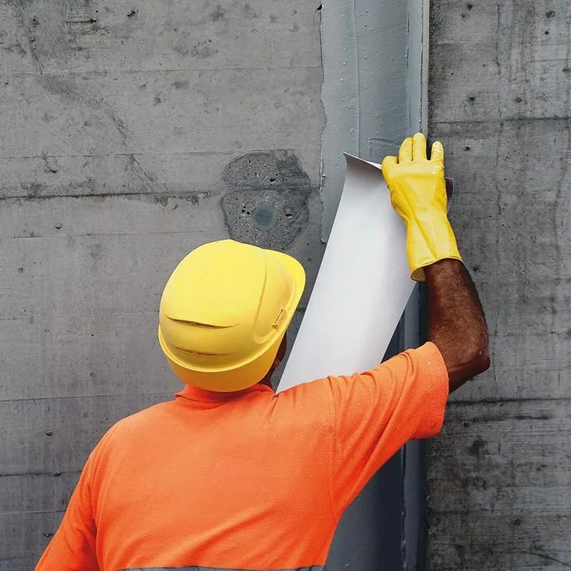 Joint tape being pressed into fresh epoxy adhesive at a vertical expansion joint